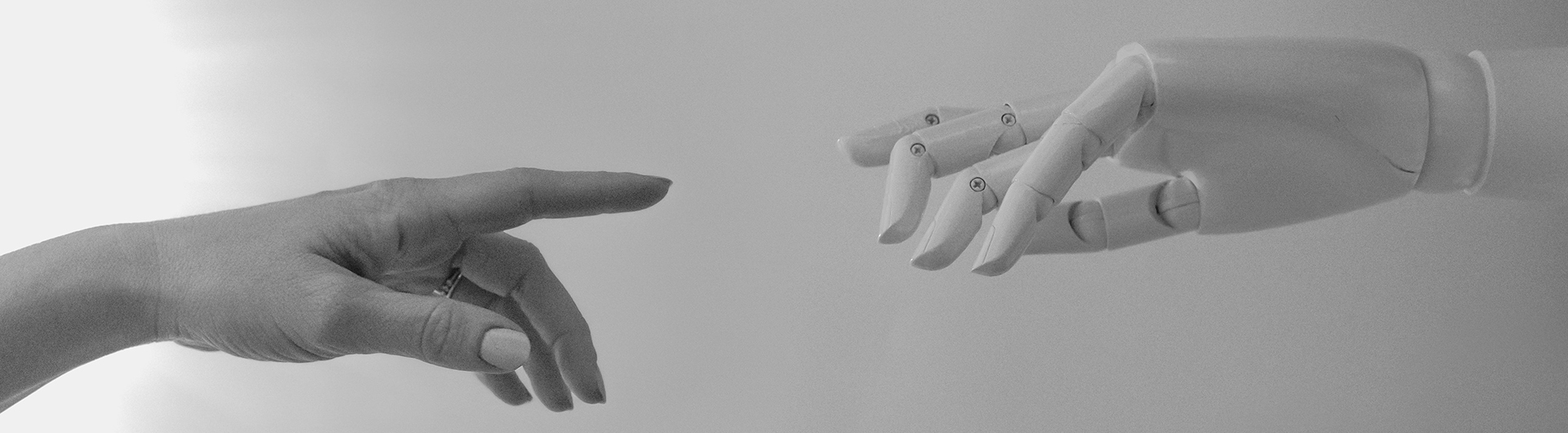human hand and robot hand pointing to each other as in Michelangelo's hand of god on the Sistine chapel (black and white)